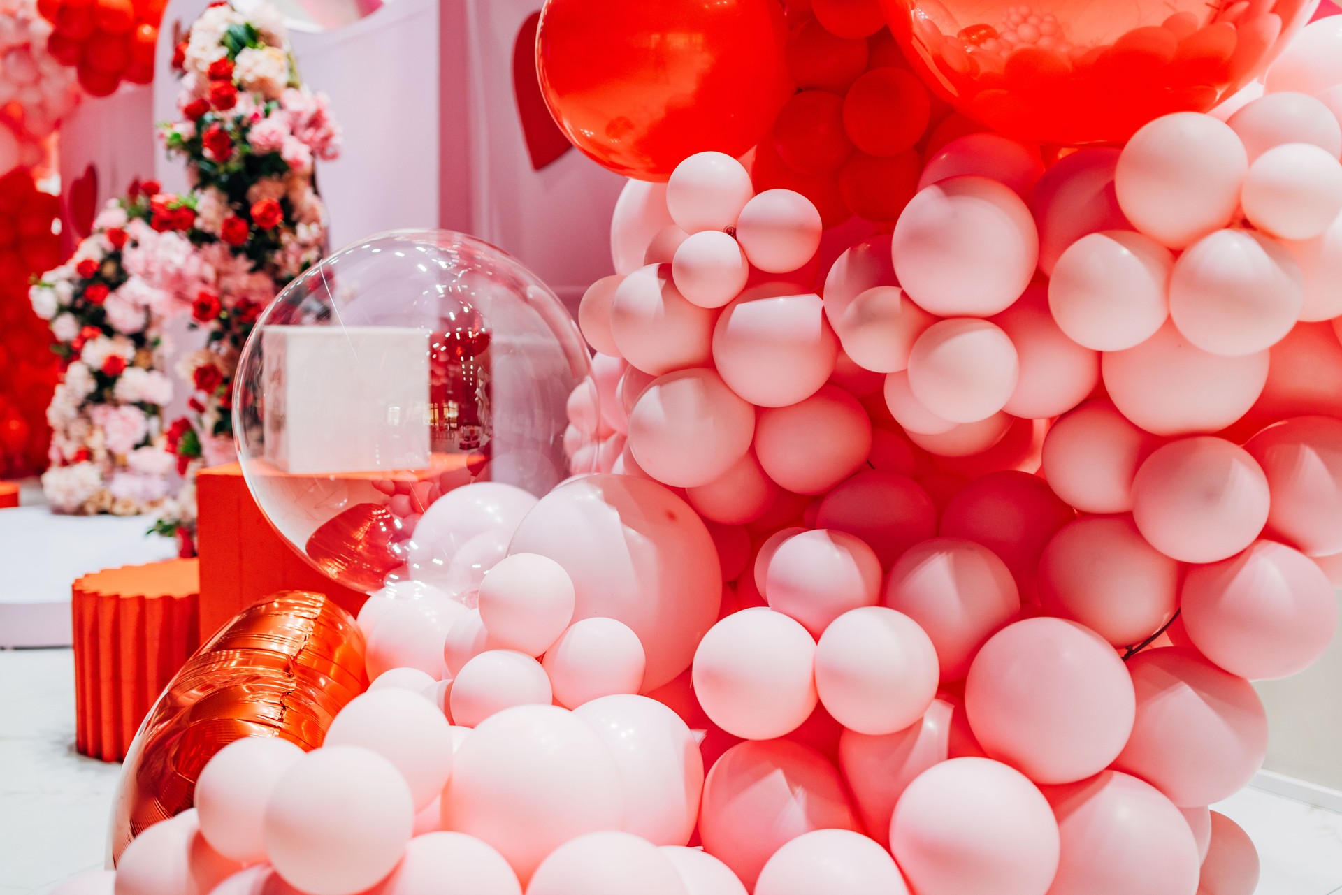 Close-up of balloon decoration in two colors, surrounded by flower arrangements